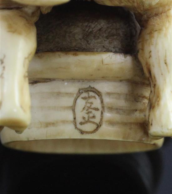 A Japanese ivory netsuke of an oni leaning on a cooking cauldron for rice, signed Tomomasa, 19th century, 4cm, loss to one toe